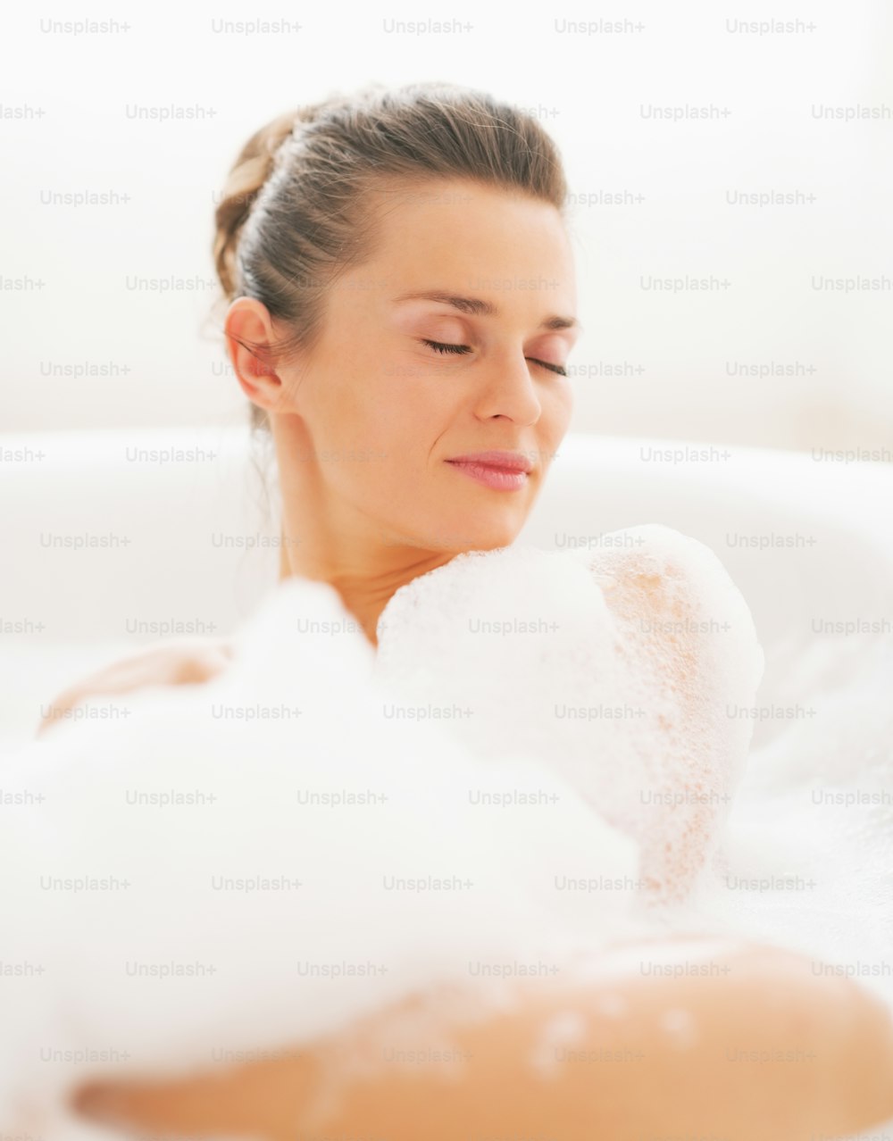 Portrait de jeune femme allongée dans la baignoire