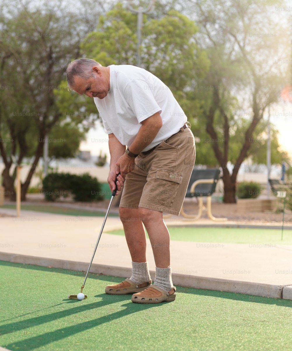 homme âgé jouant au mini-golf et alignant le coup