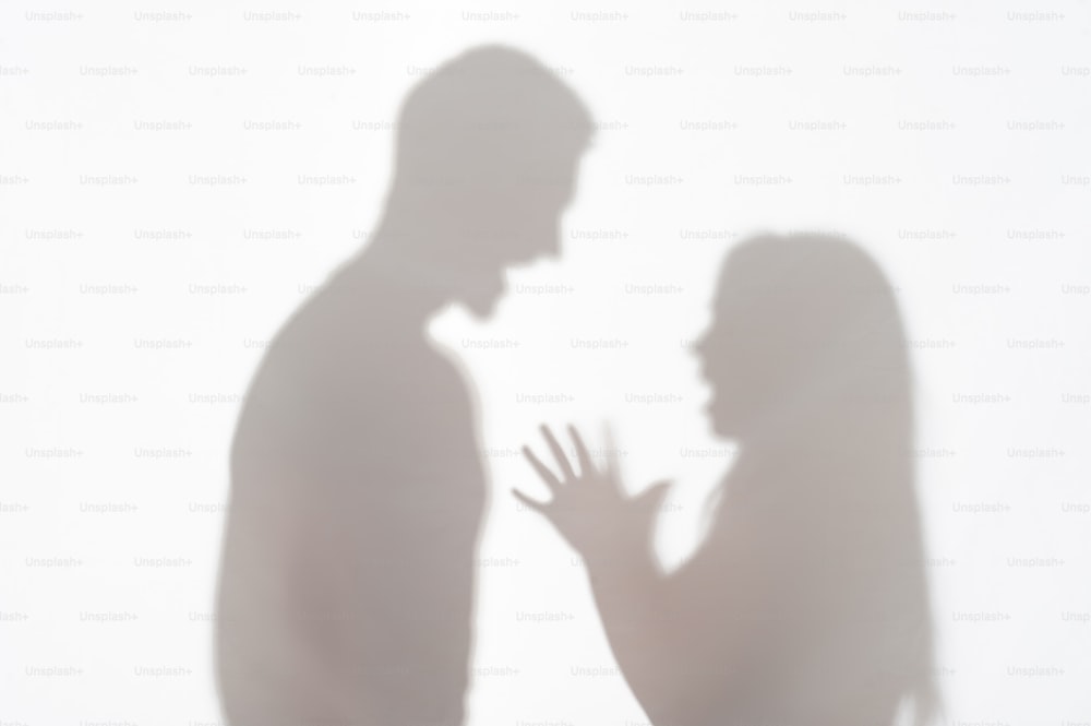 Silueta de hombre y mujer de pie sobre fondo blanco y mujer quería explicar algo gesticulando con sus manos