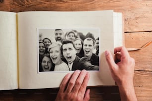 Wedding photos in album. Studio shot on wooden background.