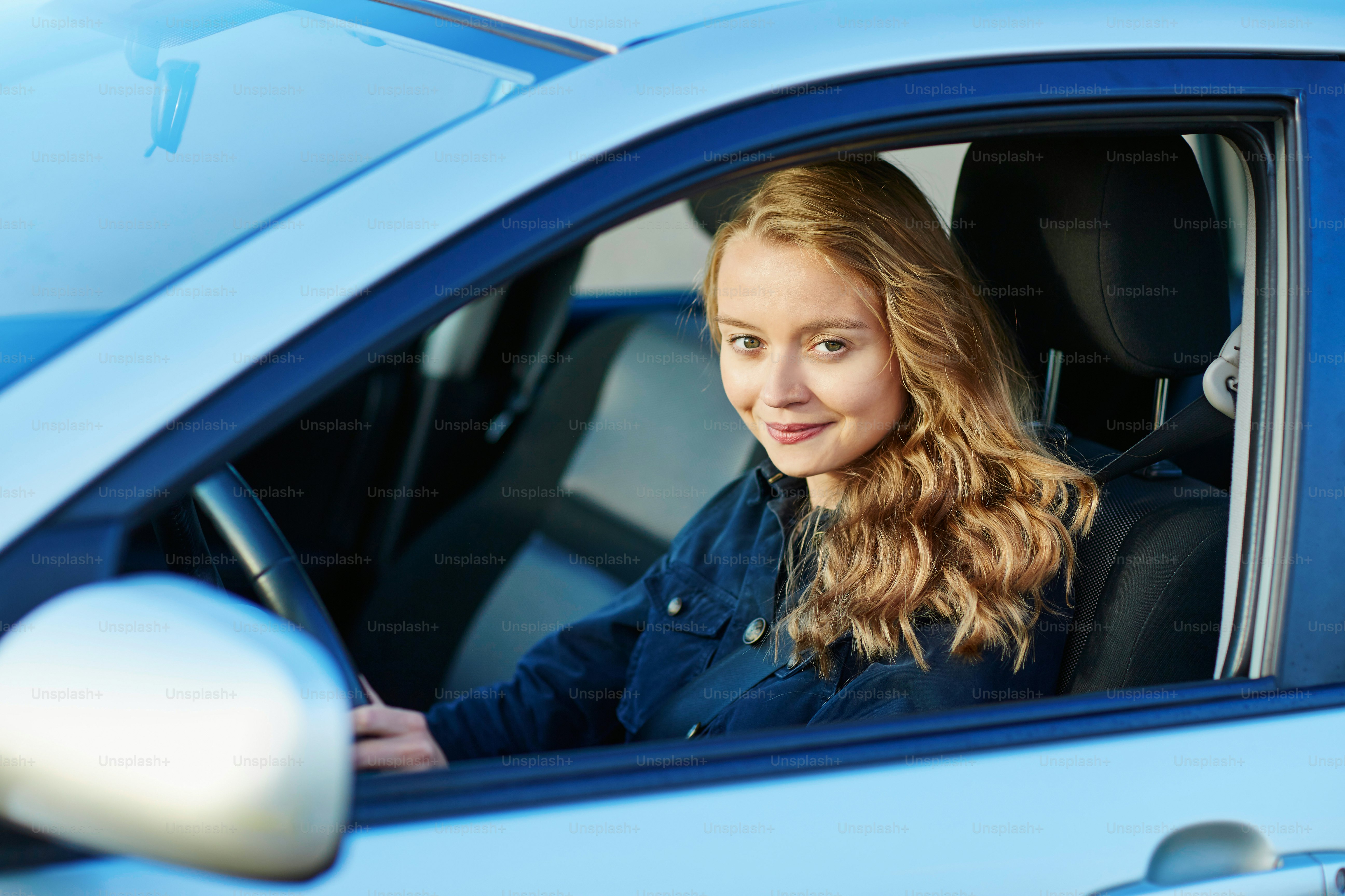 Beautiful young confident woman driving a car