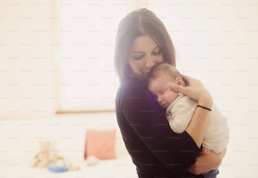 Young mother is holding her little baby