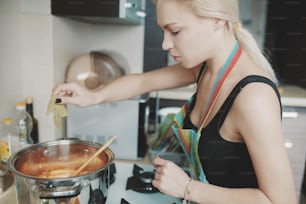 Jeune femme préparant une soupe à la citrouille dans sa cuisine