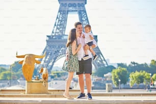 エッフェル塔の前に立って、フランスのパリで休暇を楽しむ幸せな3人家族