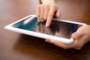 Woman Holding And Touching A Blank White Business Tablet On A Desk