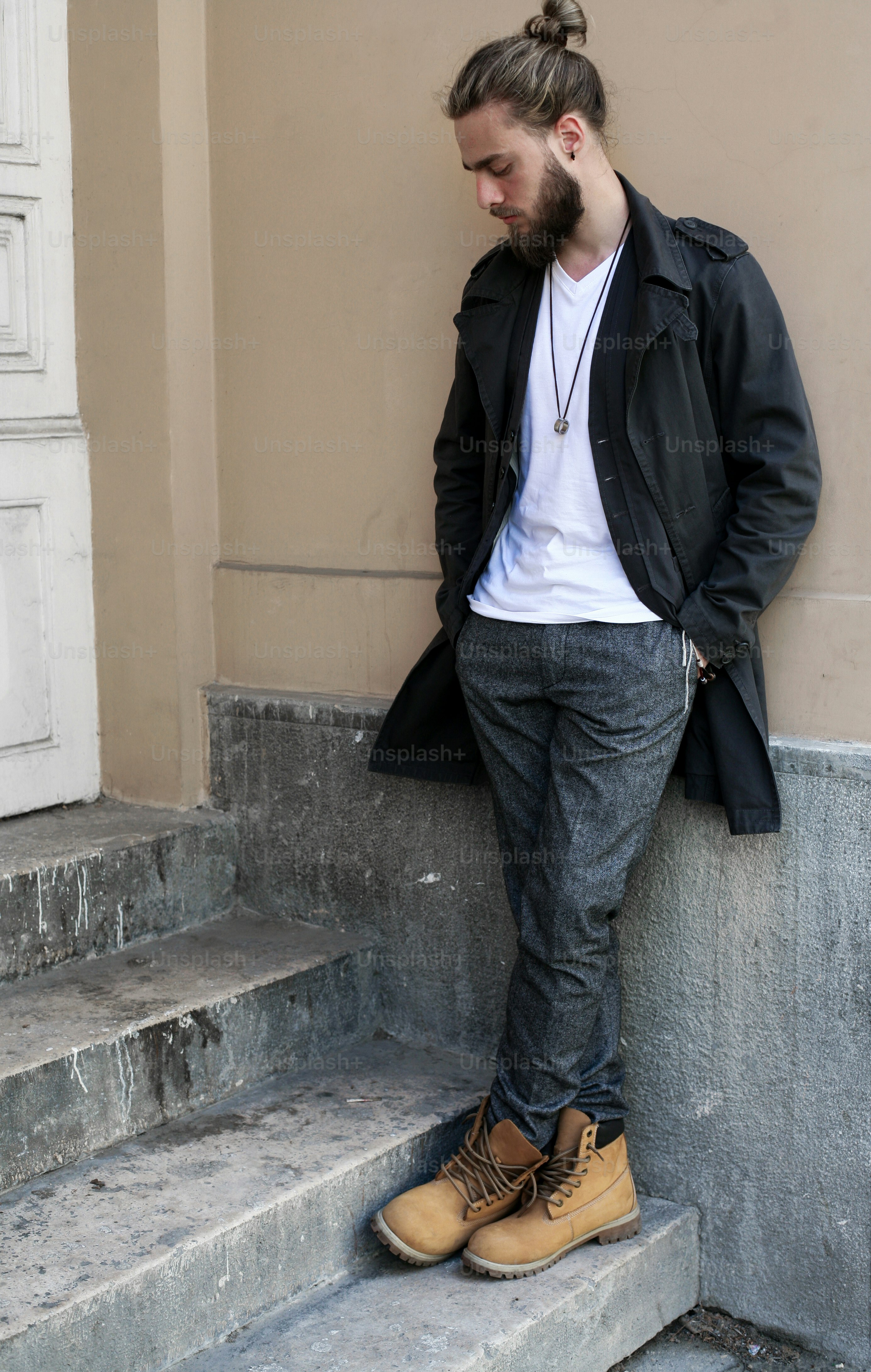 Young handsome hippie man leaning on wall.