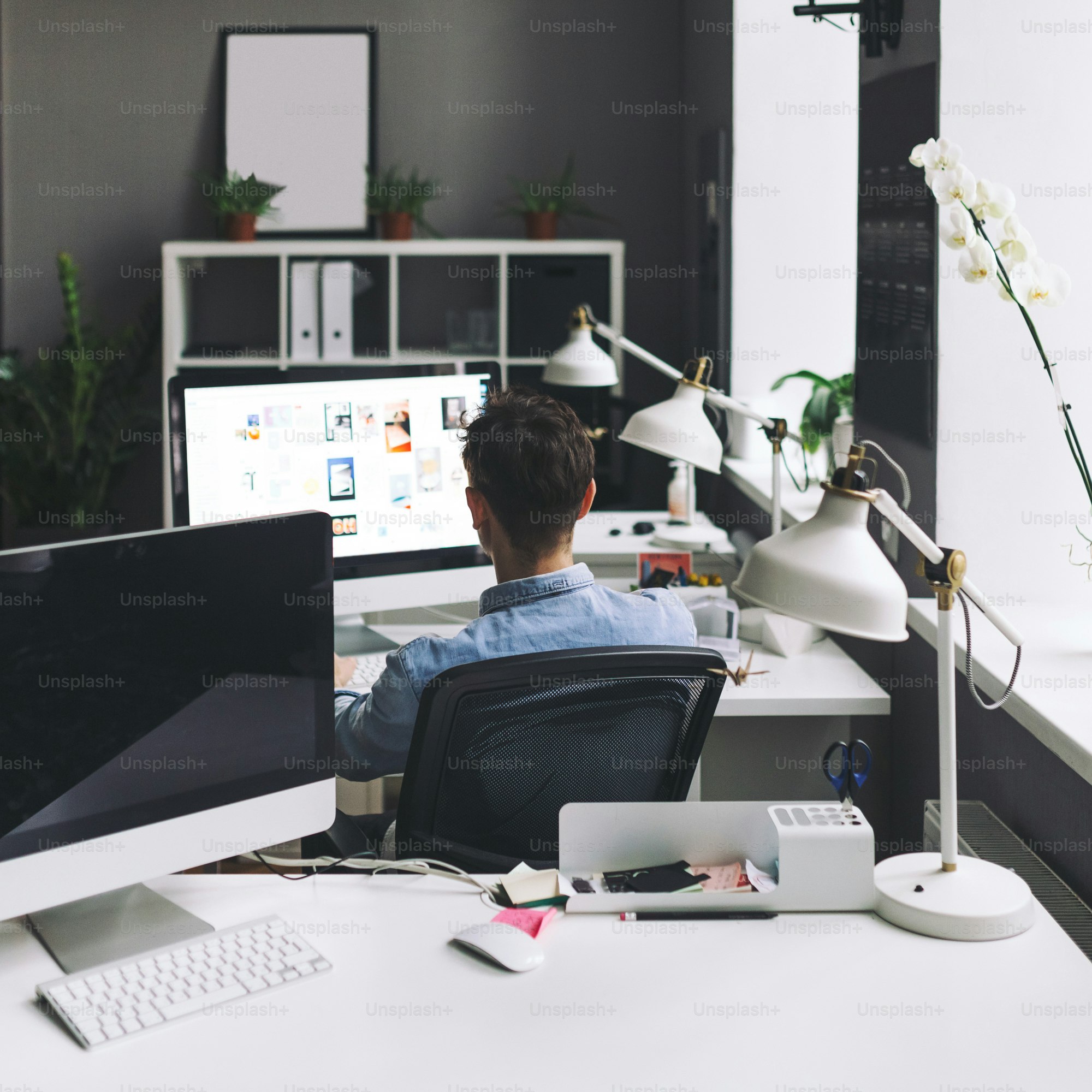 Young man working on computer while sitting at his working place in ...