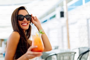 Sexy woman drinking cocktail in summer and enjoying her vacation