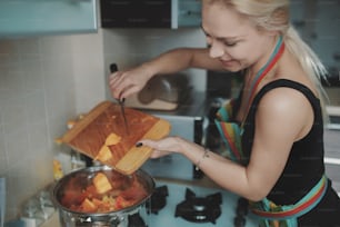 Mujer joven preparando sopa de calabaza en su cocina