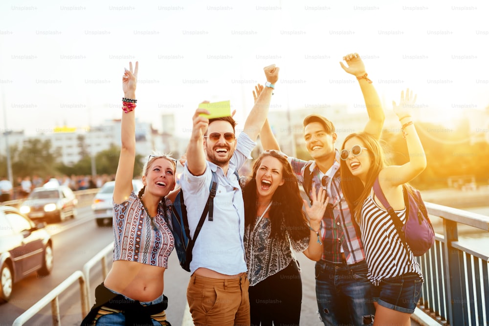 Jóvenes felices tomando selfies en la ciudad