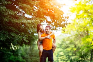 Man carrying woman piggyback after jogging is done