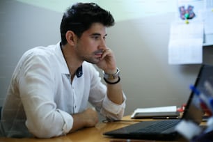 Jeune designer travaillant sur un ordinateur portable dans son bureau à domicile.