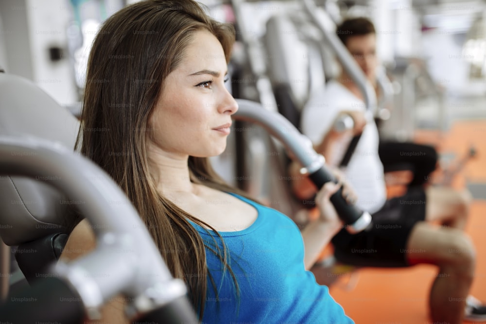 People exercising in gym on various machines