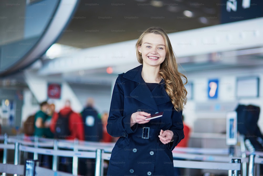 Young woman in international airport, giving her passport to an officer