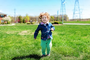 Beautiful little girl with flower on her head outdoors in sunny day pretty little girl playing outdoors in spring