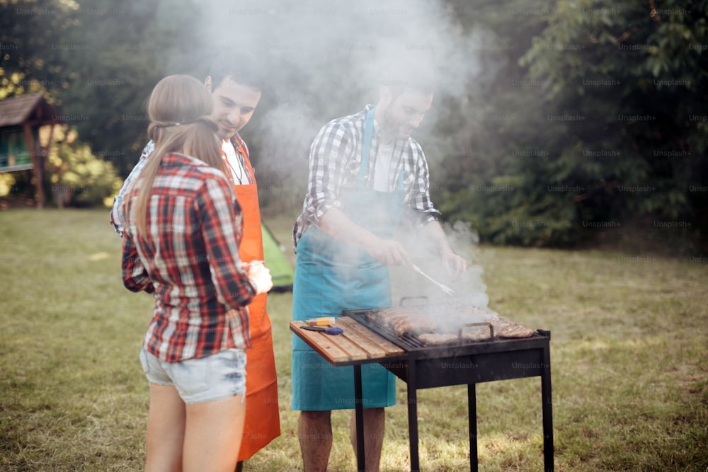 Des amis qui campent et font un barbecue dans la nature