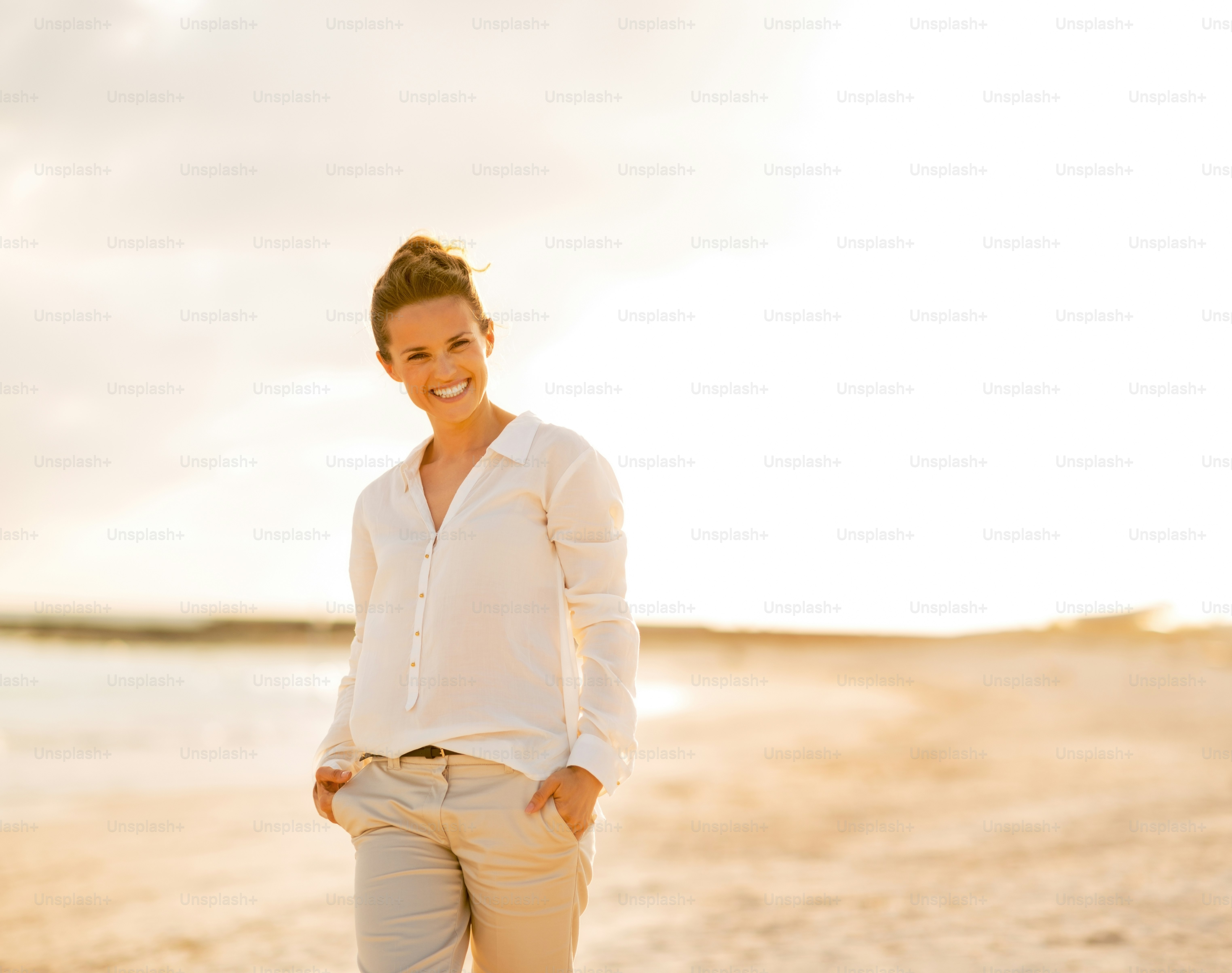Portrait of happy young woman on beach at the evening