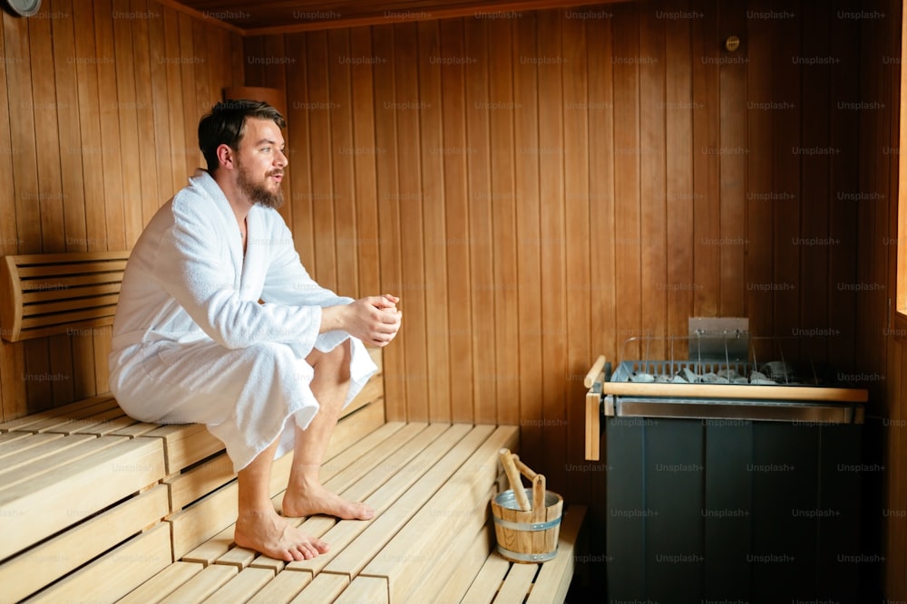 Macho saudável na sauna relaxando e desfrutando do fim de semana de bem-estar