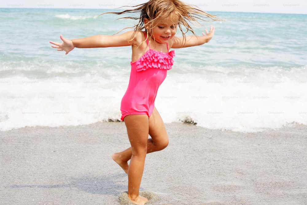 Blondes kleines Mädchen genießt am Strand.