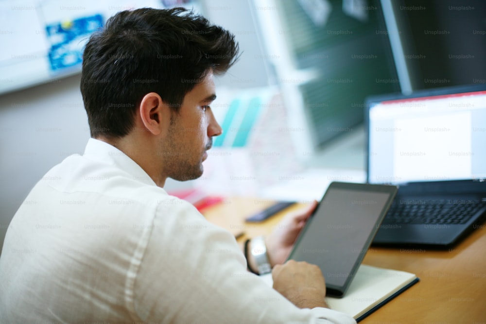 Hombre de negocios trabajando en tableta digital en la oficina.
