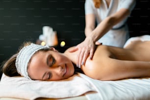 Hermosa mujer disfrutando del tratamiento de masaje dado por el terapeuta