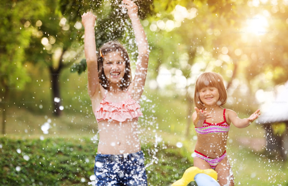 Two beautiful girls having fun outside in the garden