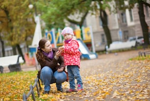 Mother and daughter at the playground by fall