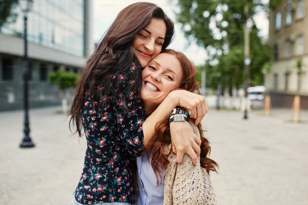 Two cheerful sisters hugging in the park