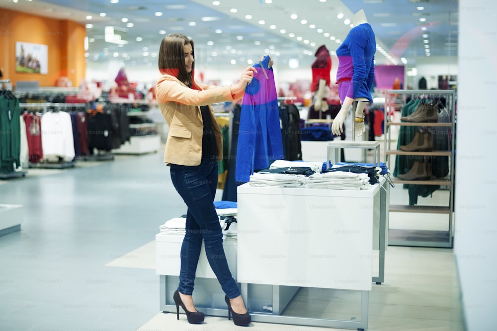 Attractive woman choosing cloths in shop