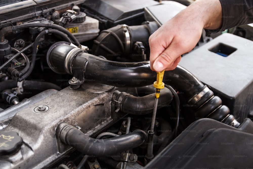 Un meccanico controlla l'olio di un'auto in riparazione