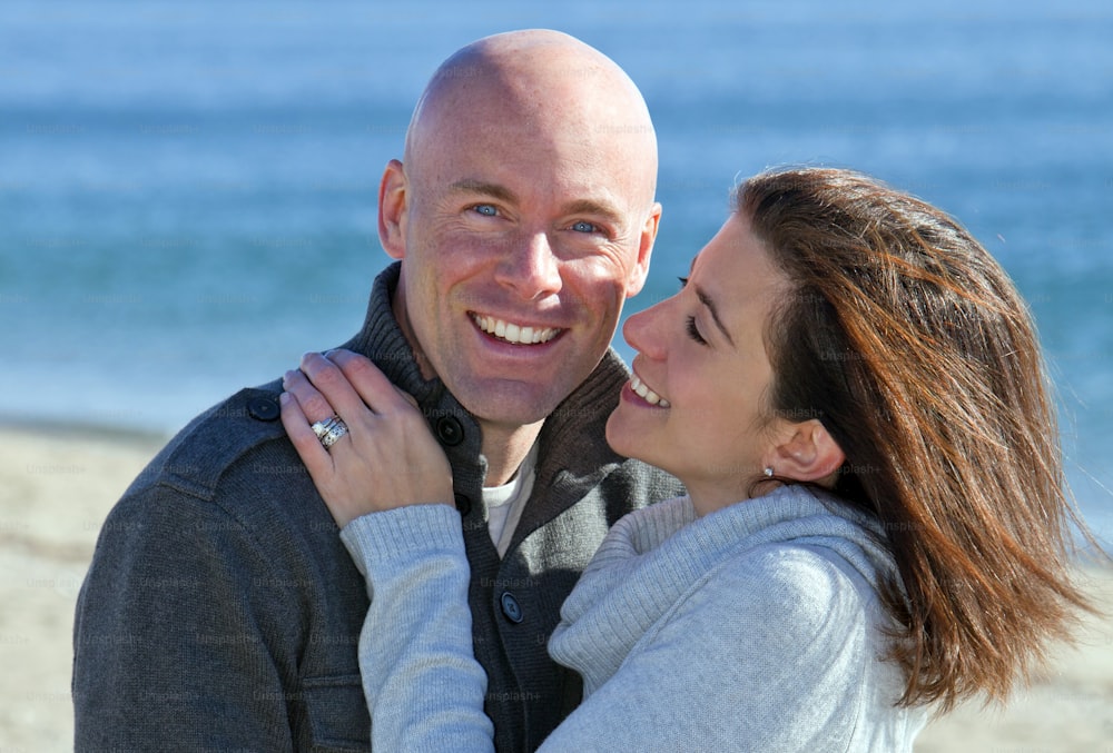 um homem e uma mulher abraçando-se na praia