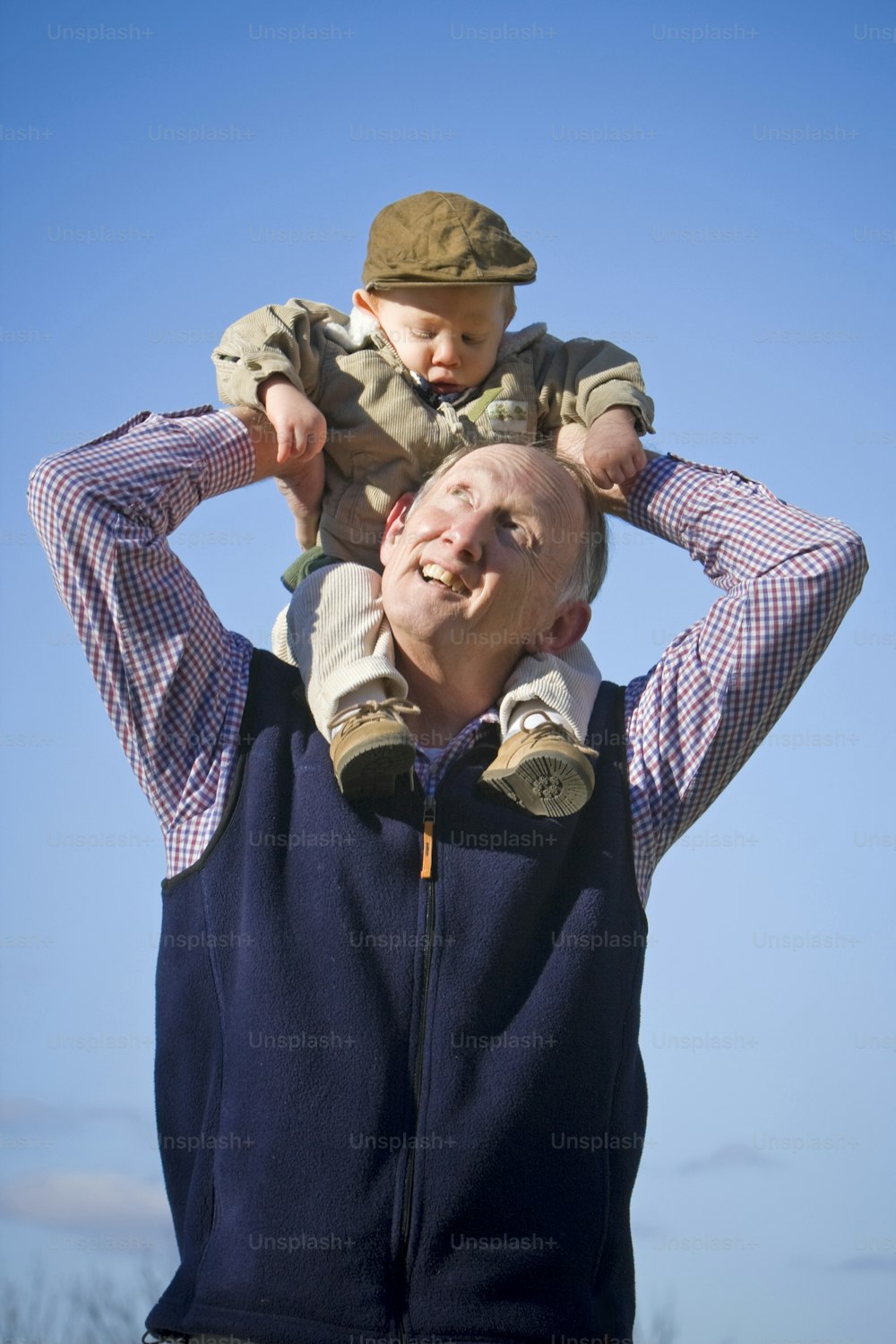 a man holding a child on his shoulders