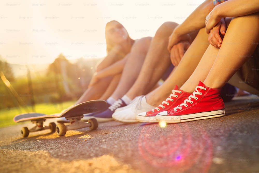 Closeup of legs and sneakers of young people on skateboard