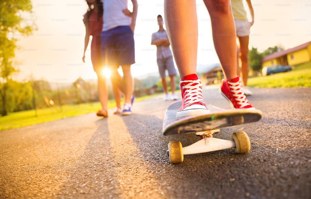 Primer plano de piernas y zapatillas de deporte de jóvenes en monopatín