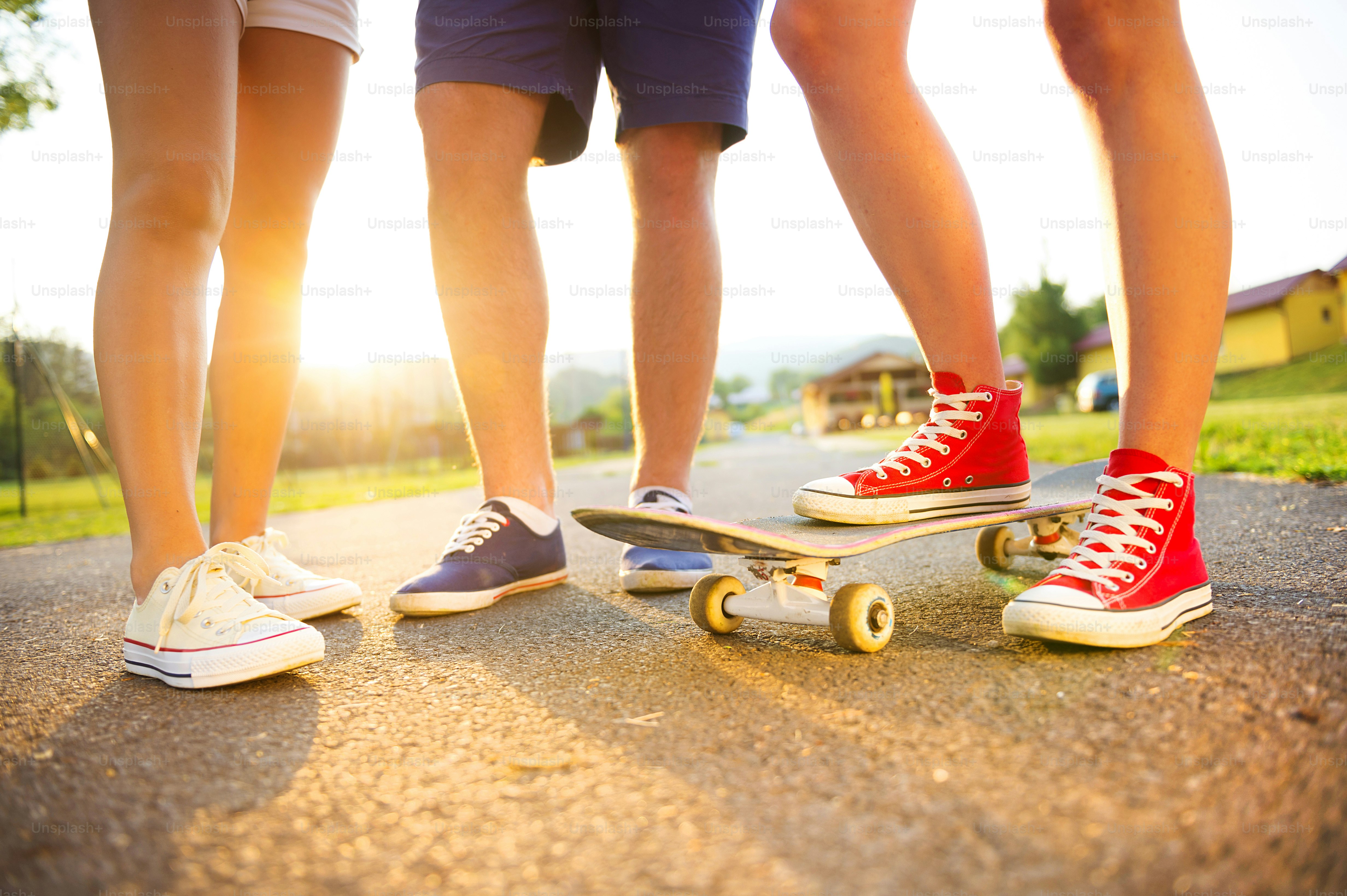 Closeup of legs and sneakers of young people on skateboard