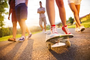 Nahaufnahme von Beinen und Turnschuhen junger Leute auf Skateboard