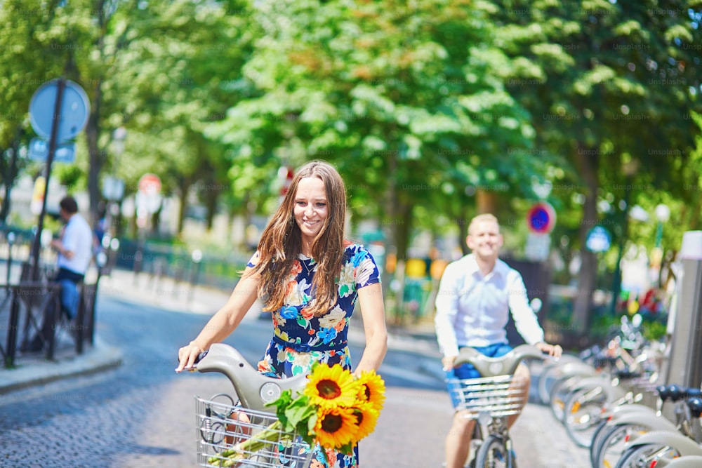 Joven pareja romántica de turistas usando bicicletas en París, Francia