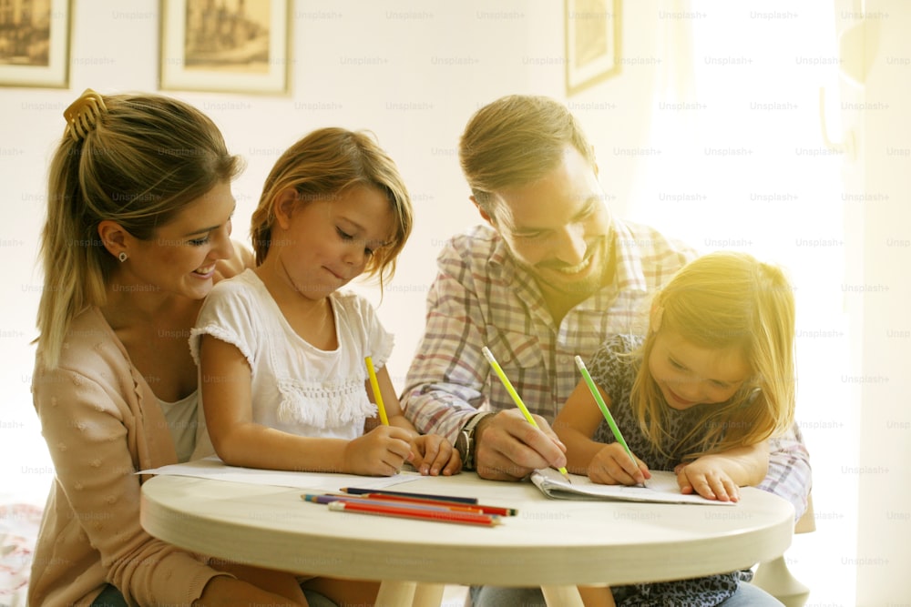 Father and mother drawing with their daughters.