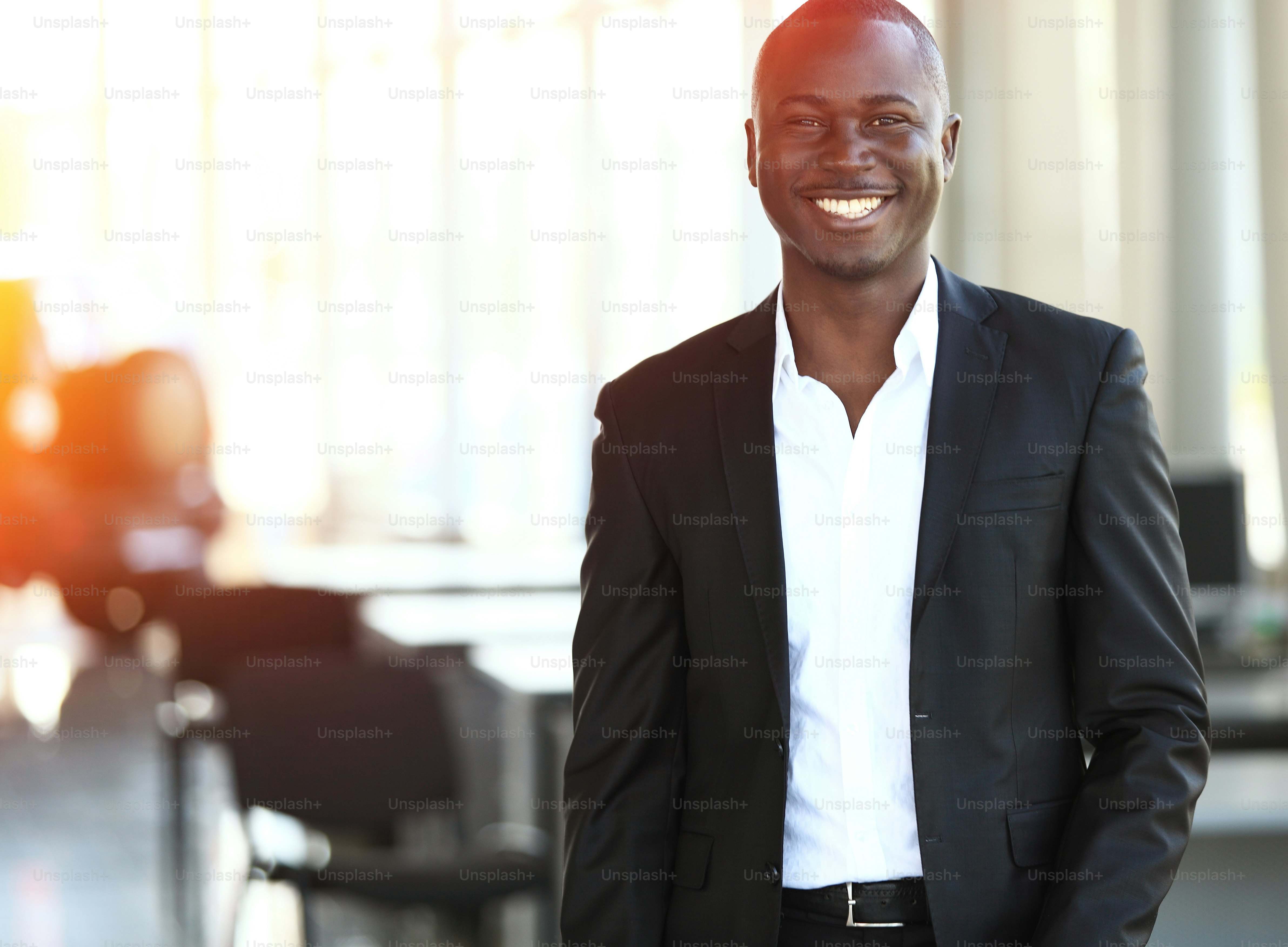 Image of African-American business leader looking at camera in working environment