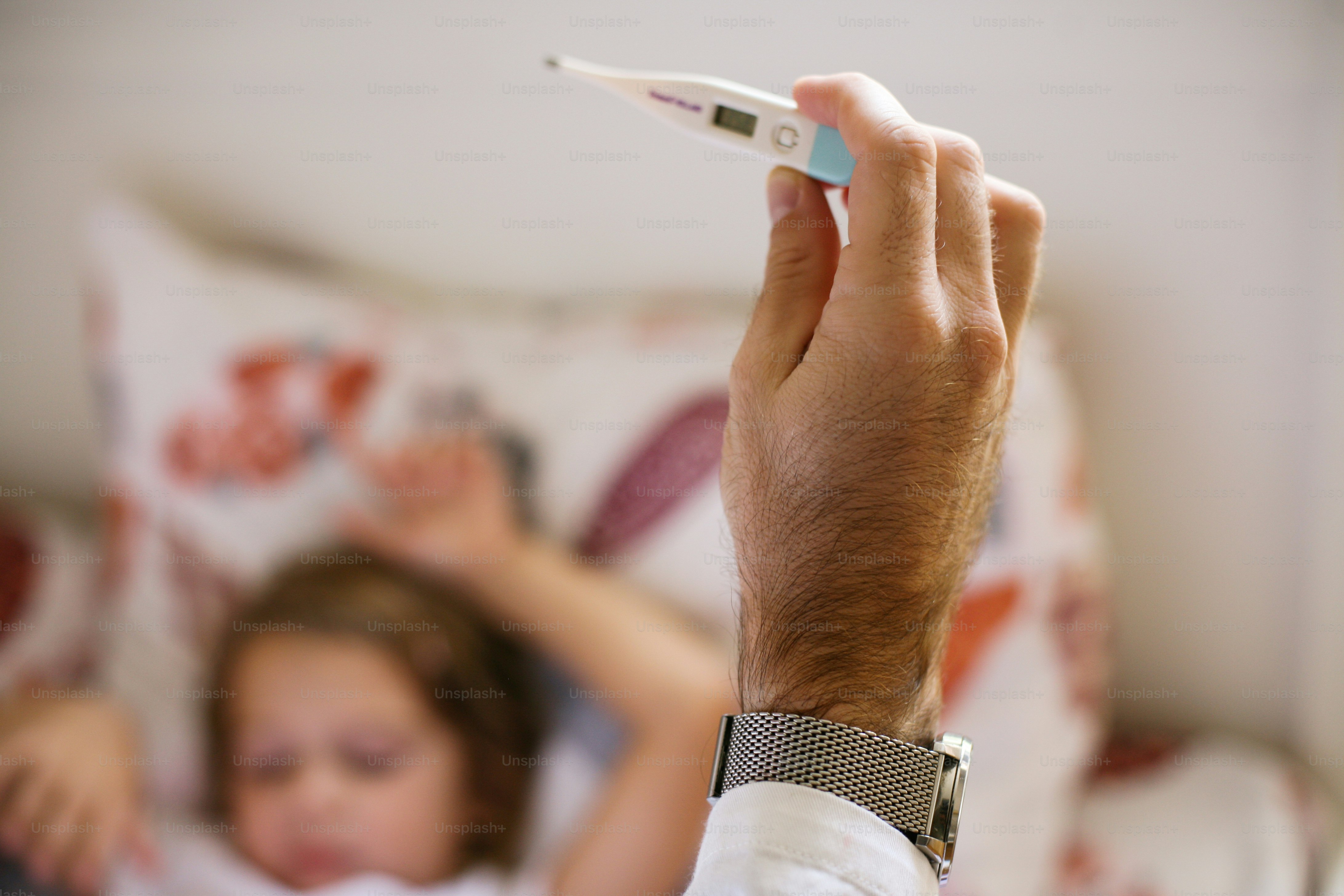 Doctor checking temperature little girl.Focus on hand.