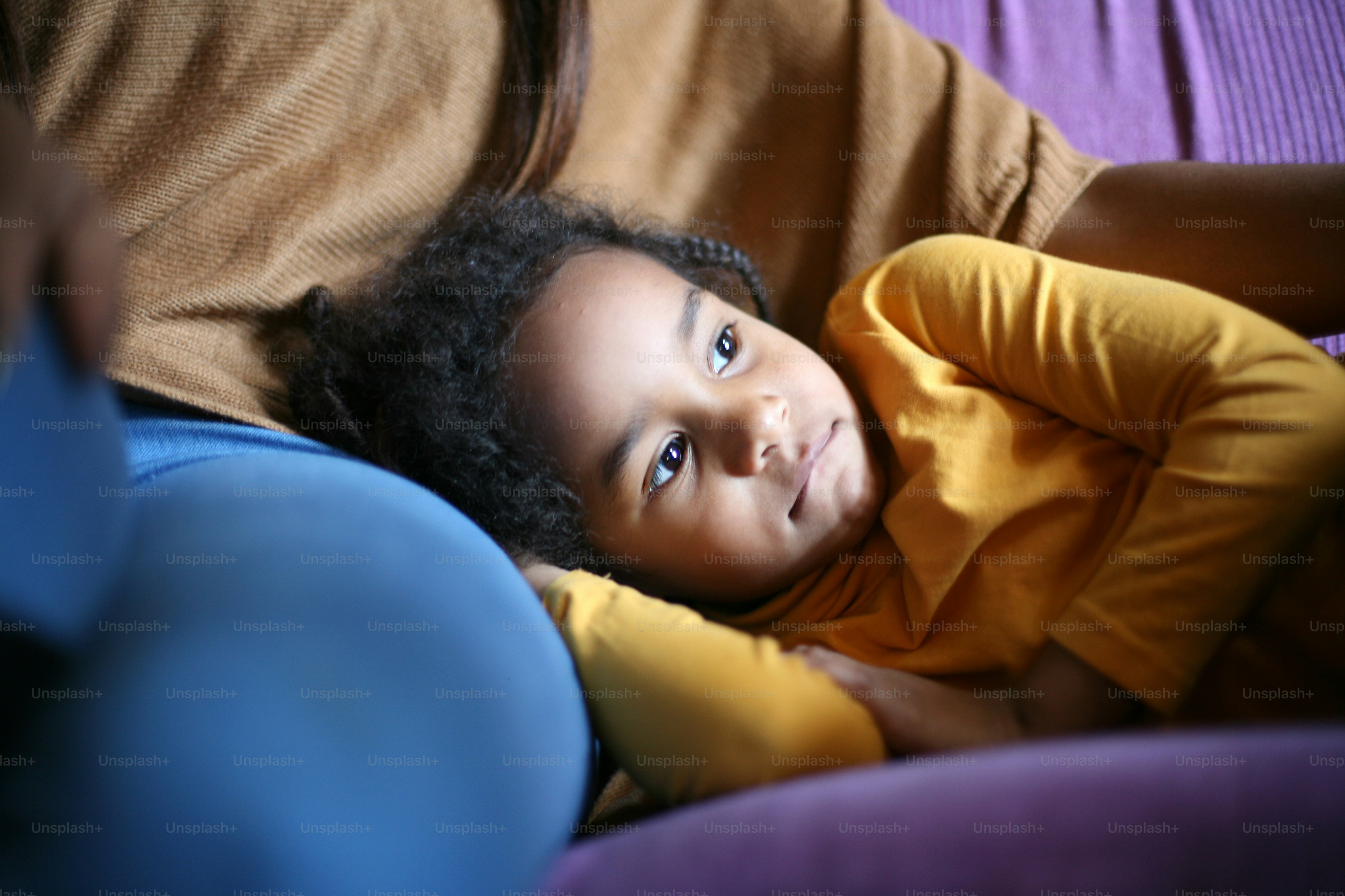 Little African girl lying on mother nap.