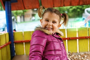 Bambina carina che guarda la macchina fotografica e sorride. Parco giochi.
