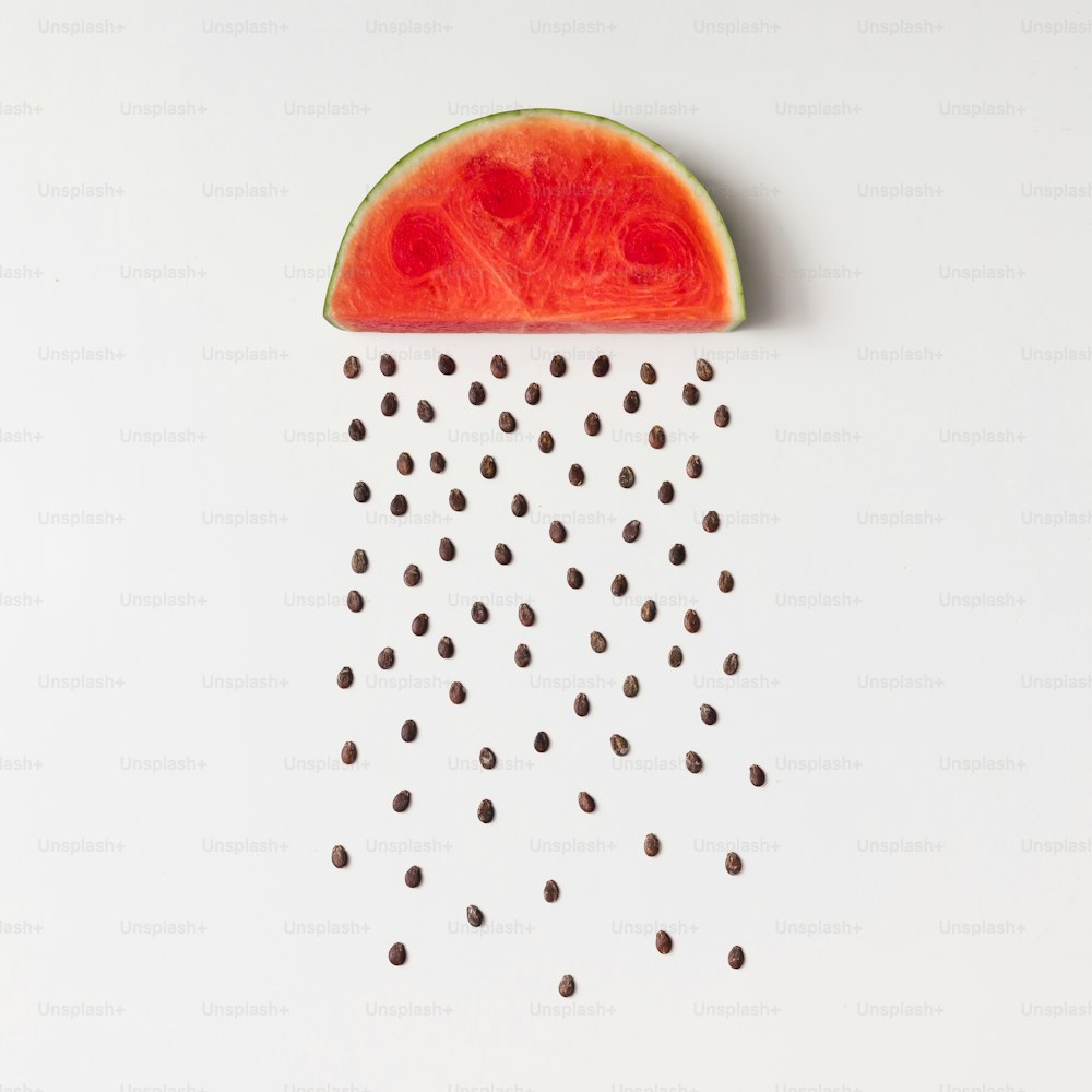 Watermellon slice with seeds raining. Flat lay. Weather concept.