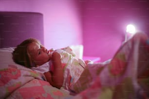Cute blonde little girl felling fear when sleeping alone.