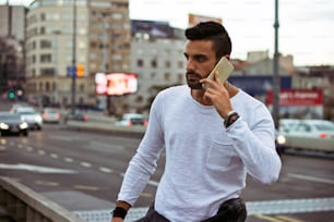 Handsome man talking on the phone outdoors
