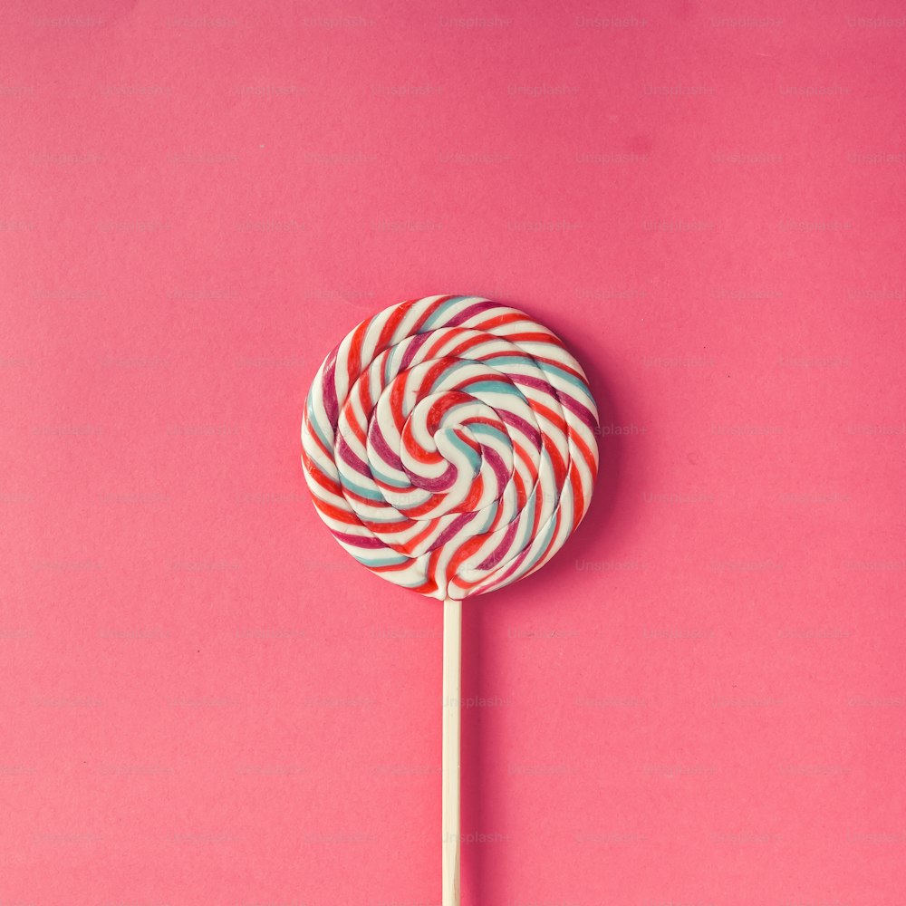 Colorful lollipop on pink background. Flat lay. Minimal concept.