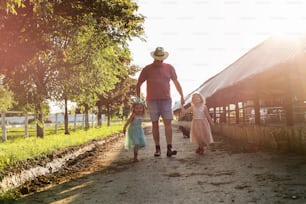 Due bambine e il nonno del villaggio, che camminano insieme e visitano la fattoria.