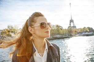Escapades automnales à Paris. Portrait d’une jeune femme élégante portant des lunettes de soleil sur un quai à Paris, France, regardant au loin