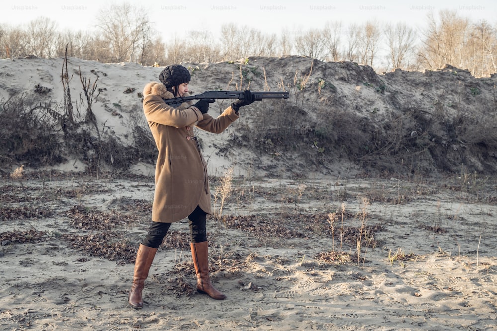 English hunting. Young beautiful woman in a hunting coat with a gun in his hand. Traditional hunting in Britain