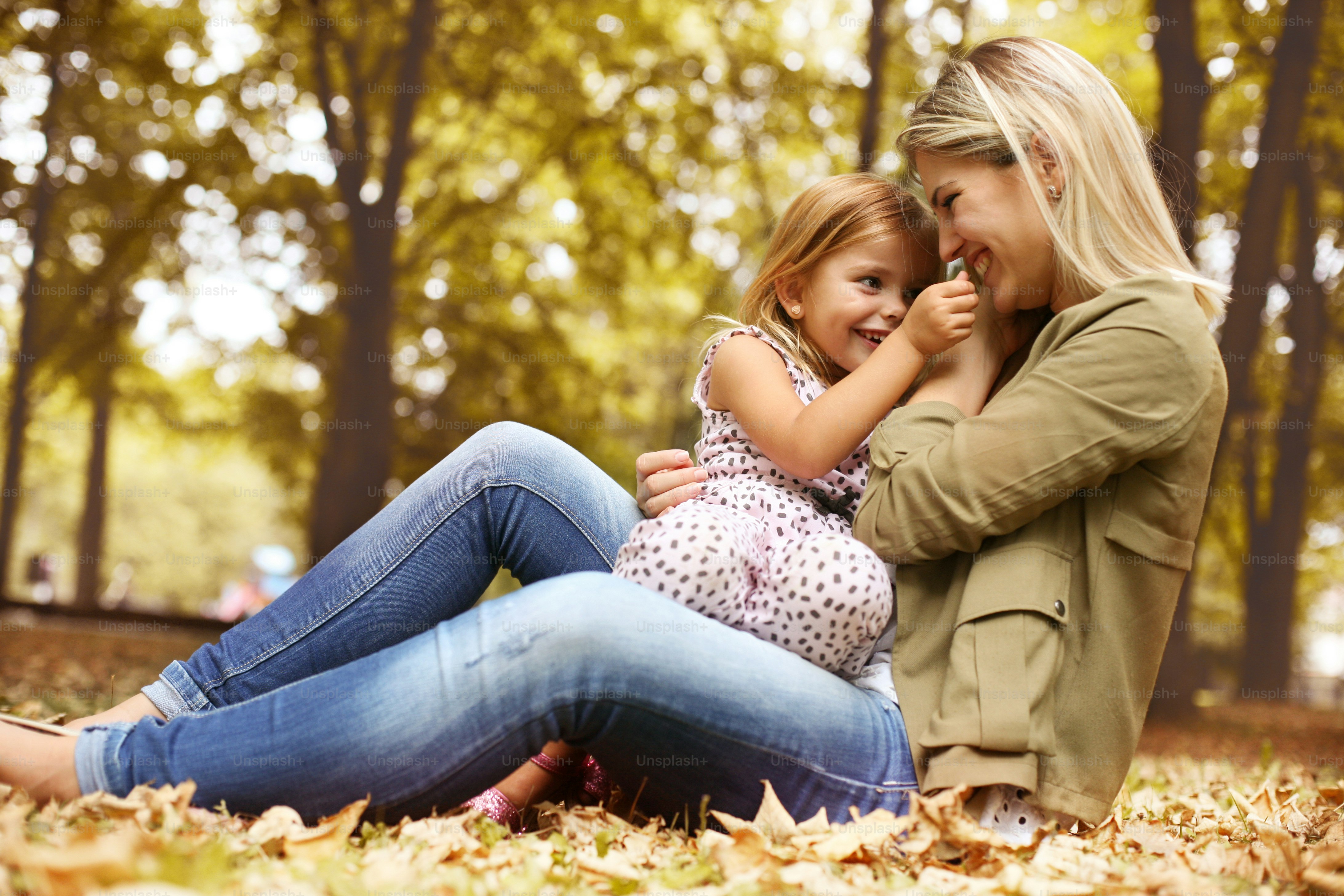 Foto zum Thema Kleines Mädchen sitzt auf dem Schoß der Mutter. Mutter ...
